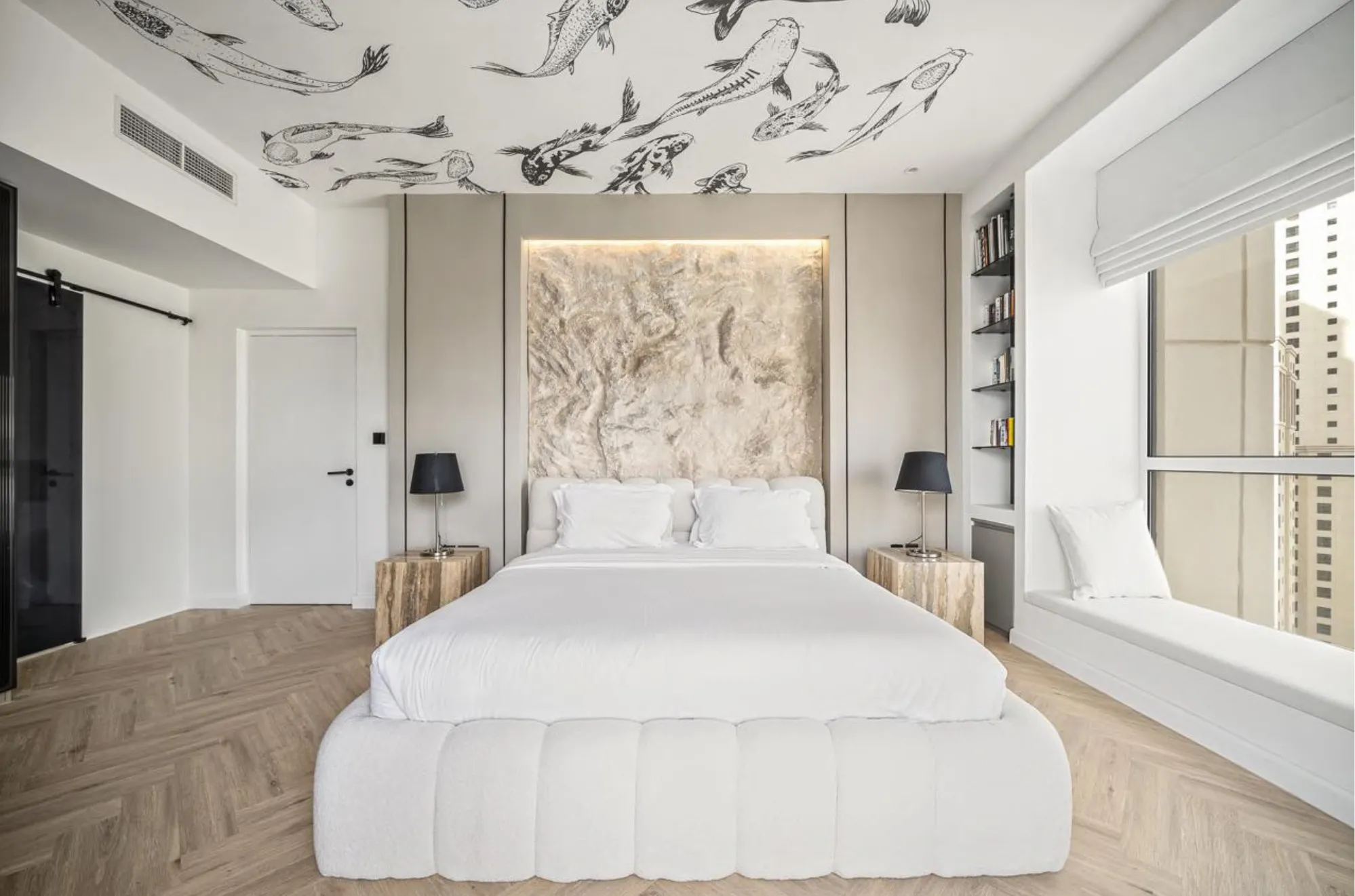 The Horizon Suite bedroom with a channel-tufted white bed, textured headboard panel and koi-print ceiling