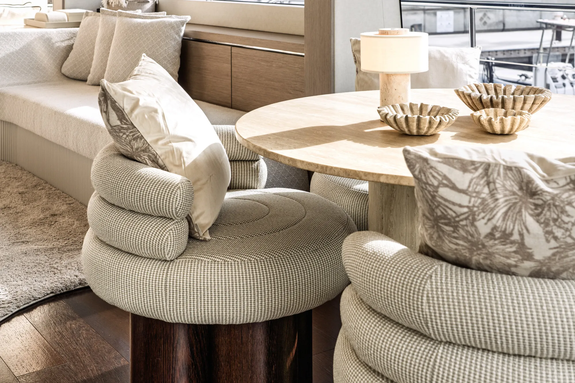 Solaria salon with linen banquette seating and a travertine table in warm afternoon light